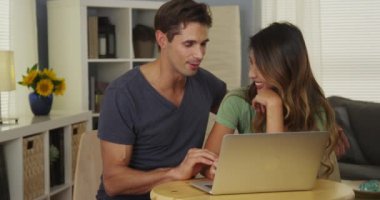 Karışık ırk çifti laptopta arkadaşlarıyla sohbet ediyor.
