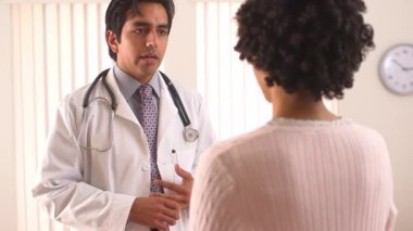 İspanyol doktor kadın hastayla konuşuyor.