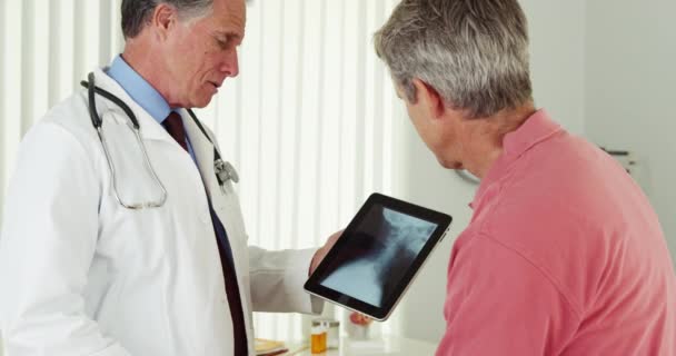 Senior Arts Gesprek Met Volwassen Patiënt Zijn Röntgenfoto Tablet — Stockvideo