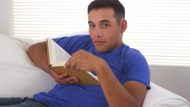 在沙发上看书的西班牙裔男人 — 图库视频影像