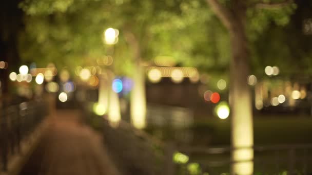 夜の都市公園の背景プレートを合成するためのぼやけた 都市公園で木や空の歩道のBokehショット — ストック動画