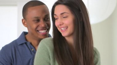 Afrikalı Amerikalı ve beyaz çift gülüyor ve konuşuyor.