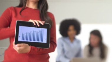 İş kadını gülümserken tablet üzerinde çizelge gösteriyor