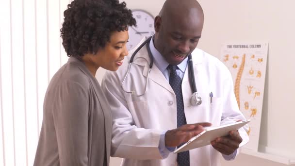 Afroamerikansk Läkare Som Använder Tablettdator Med Kvinnlig Patient — Stockvideo