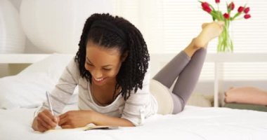 Günlüğe yazan genç Afrikalı kadın.