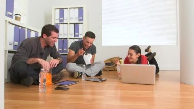İspanyol ve Kafkas ofis çalışanları yerde yemek yiyorlar.
