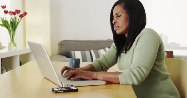 在笔记本电脑上打字的成熟的非洲女人看着屏幕 — 图库视频影像