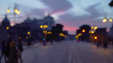 Ulusal Victor Emmanuel Anıtı 'nın yanındaki popüler İtalyan caddesinin Bokeh gece çekimi. İtalya 'nın Roma kenti yakınlarındaki geniş şehir caddesinde yürüyen turistlerin plakası bulanık.