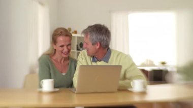 Kıdemli çift masada oturmuş gülüyor.