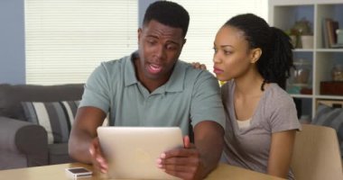 Genç siyah çift doktora boyun ağrısı hakkında tablet bilgisayar üzerinde konuşuyor.