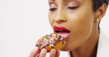 Afrikalı-Amerikalı kadın sprinkles ile lezzetli çikolatalı çörek düşkünlük