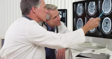 Bilgisayar üzerinde çalışan iki kıdemli doktor.