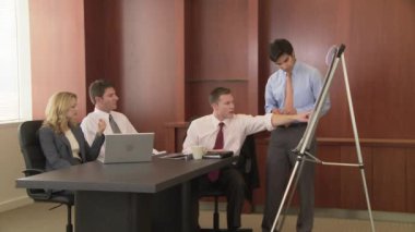 Genç iş adamı iş arkadaşlarına sunum yapıyor.
