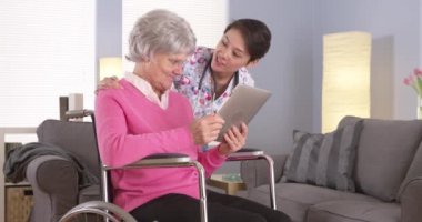 Asyalı kadın ve yaşlı hasta tablet ile konuşmak