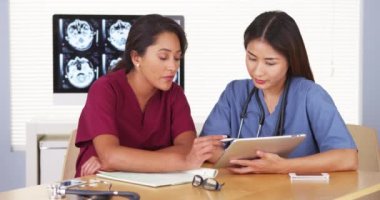Masa başında oturan Meksika ve Japon tıp doktorları