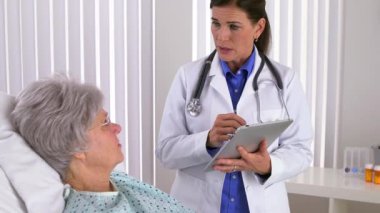 Kadın doktor tablete not alıyor.