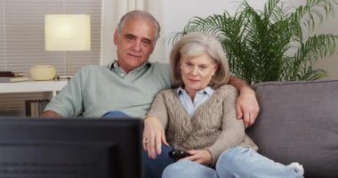 Televizyon izleyen olgun bir çift.