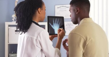 El paylaşımı siyah kadın doktor röntgen hasta tablet ile