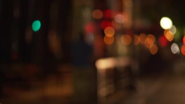 Şehir merkezindeki kaldırımın arka planında gece renk değiştiren ışıklar var. Yeşil ekran bileşimi için bulanık video arkaplanı. 4k