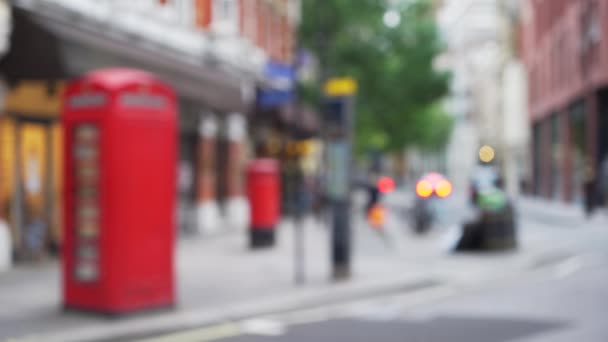 伦敦城市街道上老式红色电话亭的失焦镜头 在伦敦的城市街道上行走的人群被拍摄得很不集中 这是为背景拍摄的 — 图库视频影像