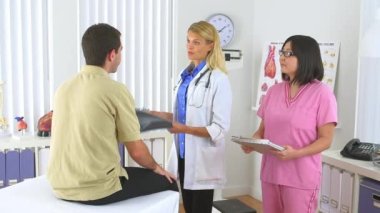 Doktor, erkek hastanın röntgenini inceliyor.