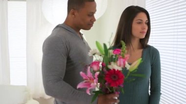 Afrikalı Amerikalı bir adam kız arkadaşına buket veriyor.