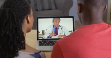 Hekim ile genç siyah çift tıbbi sorunları hakkında internet görüntülü sohbet konuşuyor.