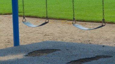 Rüzgarda sallanan iki boş salıncak