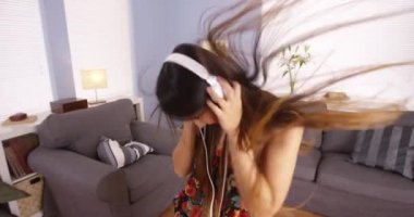 Asyalı kadın oturma odasında dans ediyor.