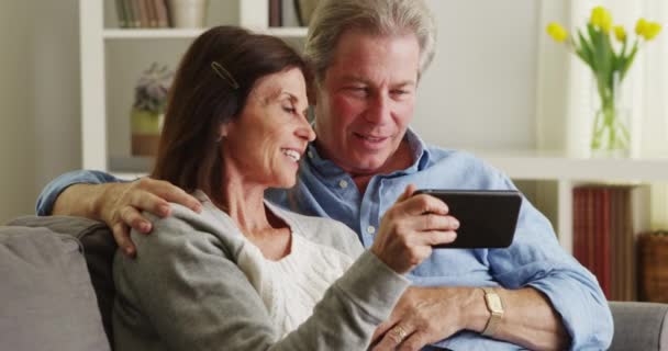 Senior Couple Happily Using Smartphone Couch — Stock Video