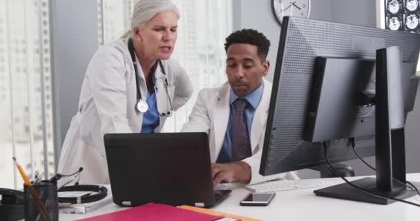 Close Dois Médicos Olhando Para Monitor Computador Comparando Notas Jovem — Vídeo de Stock