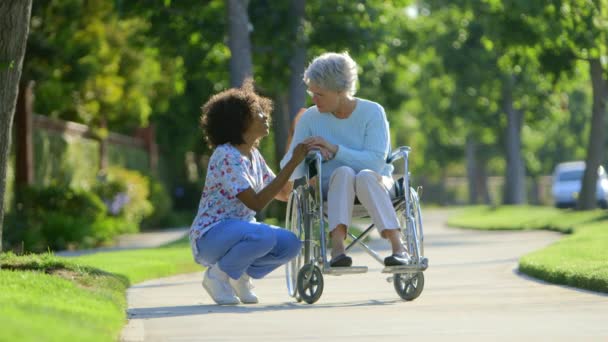 車椅子の高齢女性と話す看護師 — ストック動画