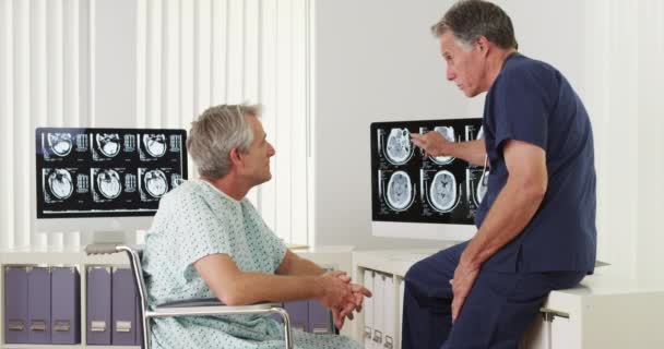 Érett Orvos Aki Elmagyarázza Röntgenfelvételeket Fogyatékkal Élő Idős Betegeknek — Stock videók