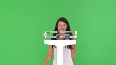 Genç bir kadın mutlu bir şekilde tartılıyor kendini