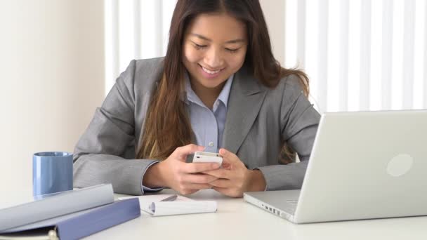 Asiatische Geschäftsfrau Schreibt Sms Während Sie Schreibtisch Arbeitet — Stockvideo