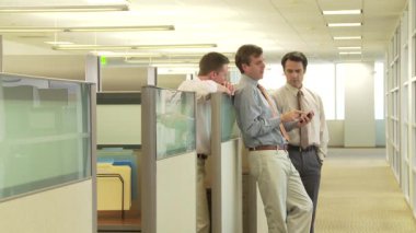 Ofis kabininde iş arkadaşları konuşuyor.