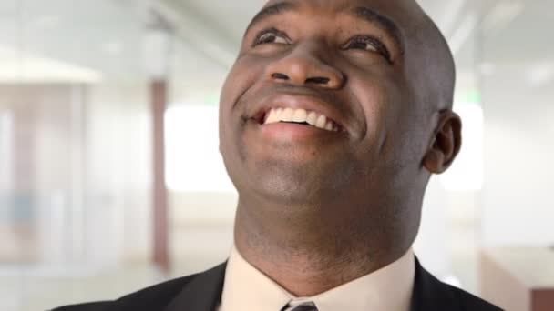 アフリカ系アメリカ人のビジネスマンが笑って画面から何かを見て — ストック動画