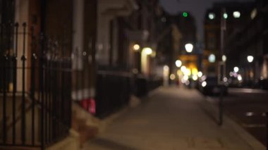 Gece vakti Londra 'daki karanlık yerleşim yerinin odak noktası dışında. Akşamları şehirdeki yerleşim alanının bulanık görüntüsü, boş ve sessiz. 4k