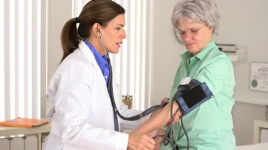 Başhekim hastanın kan basıncını ölçüyor.