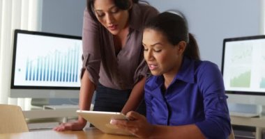 İspanyol iş kadınları meslektaşı ile tablet bilgisayarda çalışma