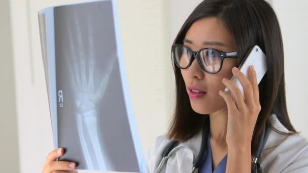 中国医生在电话中与合作方讨论X光片 — 图库视频影像