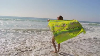 Okyanus kıyısında esintili genç bir kadın.