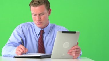 İş adamı yeşil ekranda notlar yazıyor ve tablet üzerinde araştırma yapıyor