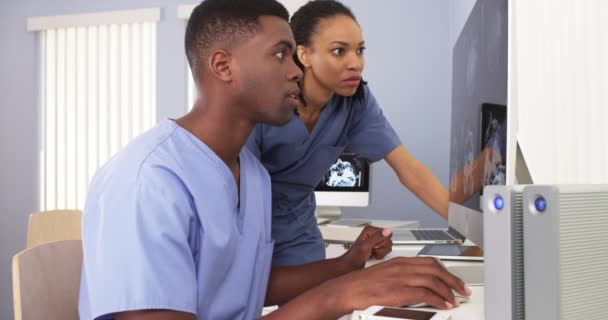 Два Афроамериканских Хирурга Синих Халатах Работают Компьютерных Станциях — стоковое видео