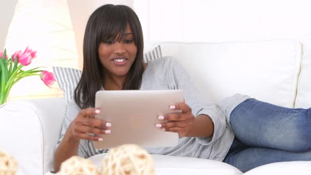 非洲裔美国妇女靠着平板电脑躺在沙发上 — 图库视频影像