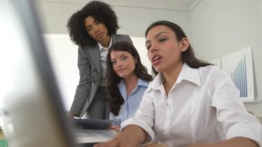 Dizüstü bilgisayardaki üç iş kadını kameraya gülümsemek için ara verdi