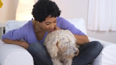 Afro-Amerikalı kadın evcil köpeğin üzerinde dinleniyor.
