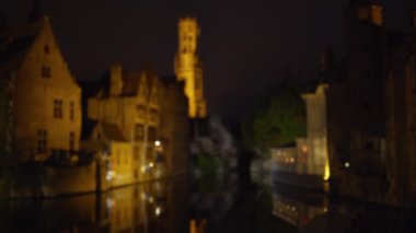 Bruges kanallarının arka plan plakası geceleri bulanık oluyor. Yeşil ekran bileşimi için bulanık dış gece video arkaplanı. 4k