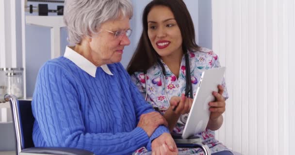 Mexican Caregiver Sharing Tablet Elderly Patient — Stock Video