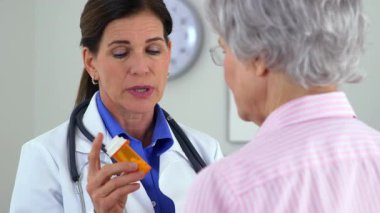 Kıdemli doktor hastaya ilaç tedavisi hakkında olumlu konuşuyor.